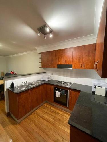 雪梨的住宿－Comfortable 3 Bedroom House Pyrmont，厨房配有水槽和炉灶 顶部烤箱