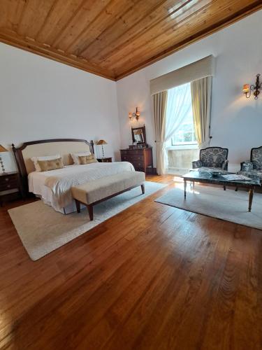 a large bedroom with a bed and a table at Solar de Almeidinha in Mangualde