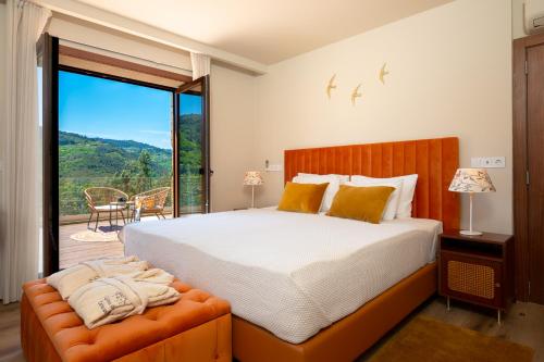 a bedroom with a large bed and a balcony at Quinta de Cabanas Douro - By Unlock Hotels in Penha Longa