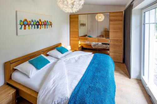 a bedroom with a large bed with a blue blanket at Ferienhaus Chalet Bergblick in Stryck