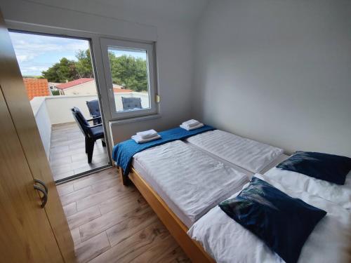 - une chambre avec un lit et une grande fenêtre dans l'établissement Apartments Fida, à Vir
