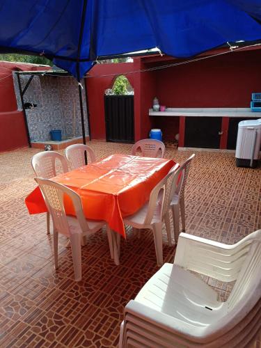 Una mesa y sillas con una mesa naranja y una sombrilla. en منزل كامل قرب شاطئ بوزنيقة, en Kasba Bou Hamira