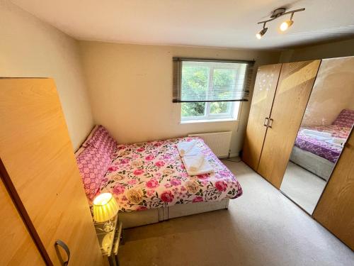 a small bedroom with a bed and a window at Solo Lodge in Windsor & Legoland in Windsor