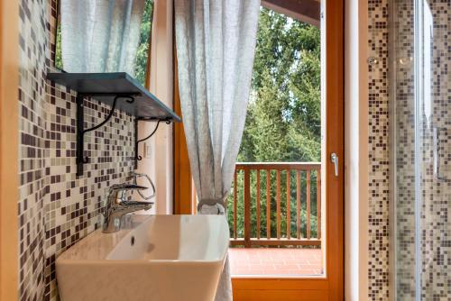ein Bad mit einem Waschbecken vor dem Fenster in der Unterkunft Casa Lidia Luxury apt 8 in Varda