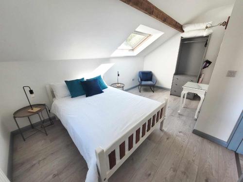 - une chambre avec un grand lit blanc et des oreillers bleus dans l'établissement Hazel View Apartment, à Bunbeg