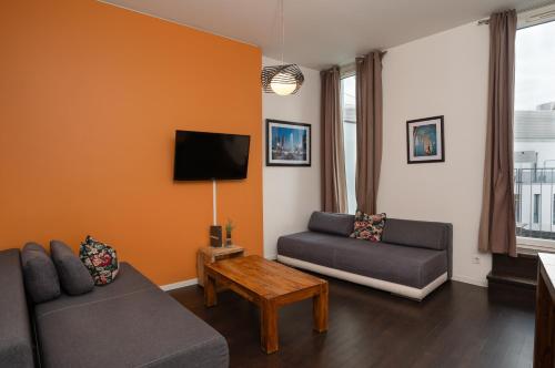 a living room with a couch and a tv at Holiday at Alexanderplatz Apartments in Berlin