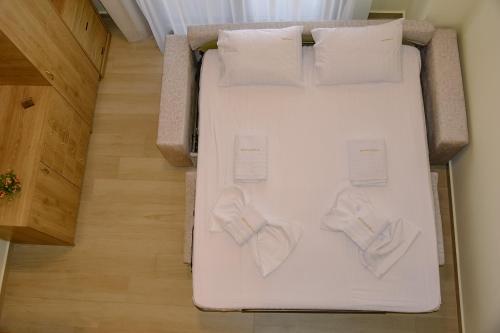 a white bed with two bow ties on it at Sea Legends in Nea Vrasna