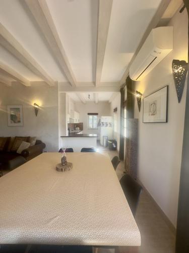 une salle à manger avec une table et des chaises blanches dans l'établissement Superbe maison avec jacuzzi, à Aregno