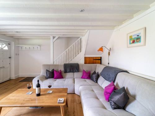 a living room with a gray couch with pink pillows at Pass the Keys Unicorn Cottage Rural Cotswold Escape in Great Rollright