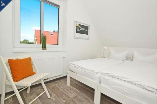 1 dormitorio con 1 cama, 1 silla y 1 ventana en Waldsiedlung DHH Waldhaus 6, en Korswandt