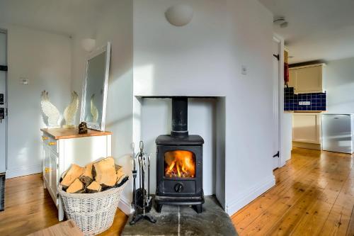 a fireplace in a living room with a stove at Orchard Cottage: Lake Access & Facilities On-site in Somerford Keynes