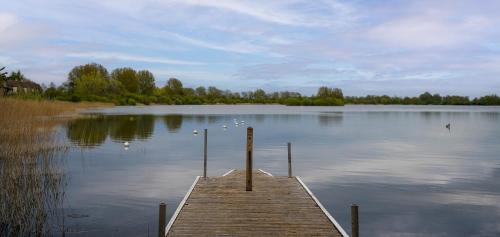 un quai au milieu d'un grand lac dans l'établissement Orchard Cottage: Lake Access & Facilities On-site, à Somerford Keynes