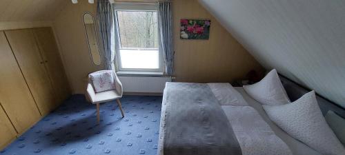 a bedroom with a bed and a chair and a window at Ferienwohnung Lucke in Luftkurort Lückendorf