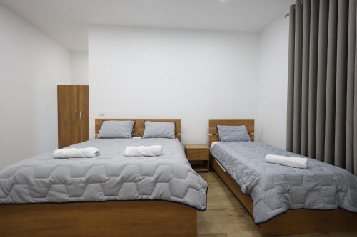 2 nebeneinander sitzende Betten in einem Schlafzimmer in der Unterkunft Guesthouse Aurel in Berat