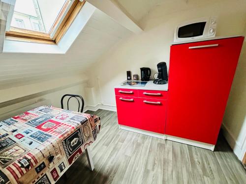 a red cabinet in a room with a bed at appartement 2 pieces in Aurillac