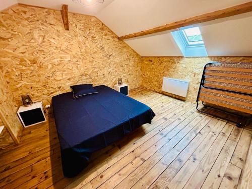 - une chambre avec un lit bleu dans un mur en pierre dans l'établissement appartement 2 pieces, à Aurillac