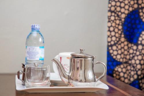 a tea kettle and a bottle of water on a table at KaribuGuestHouse in Fort Portal