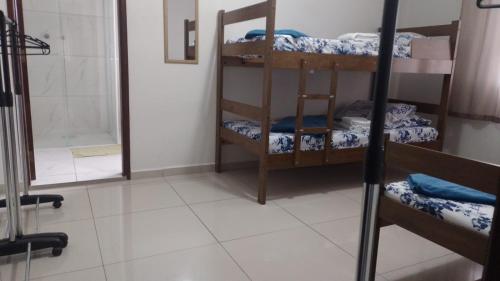 a room with three bunk beds and a shower at POUSADA DAS NAÇÕES ll in Indaiatuba