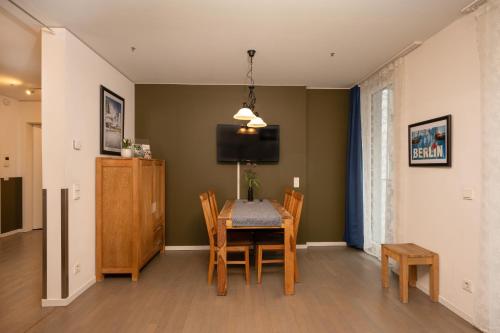 a dining room with a table and chairs and a television at Holiday at Alexanderplatz Apartments in Berlin