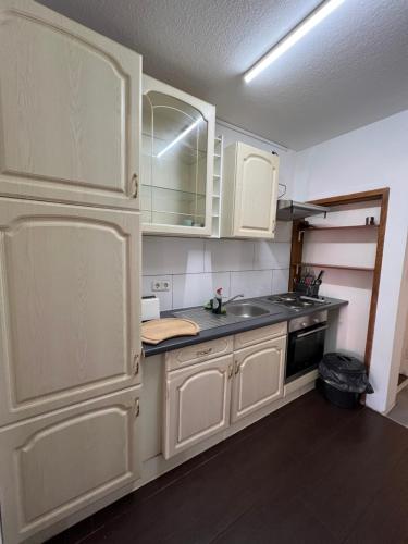 eine Küche mit weißen Schränken und einem Waschbecken in der Unterkunft Zimmervermittlung Hemelingen in Bremen