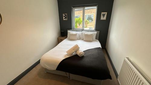 a small bedroom with a bed with a window at Cotswolds-Stroud-Comfy 4 bed house-Sleeps 10-Free Parking-Wifi in Ebley