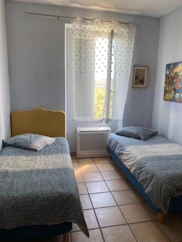 sypialnia z dwoma łóżkami i oknem w obiekcie Maison le Rêve w mieście Falicon