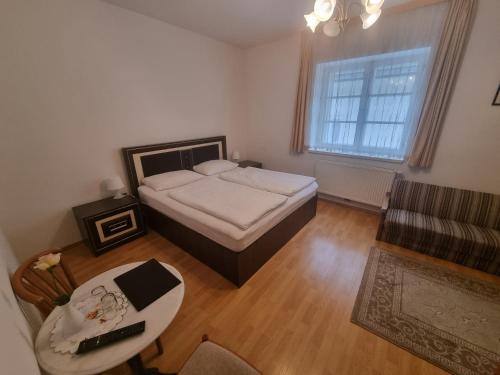 1 dormitorio con cama, mesa y sofá en Pension Weisses Lamm, en Melk