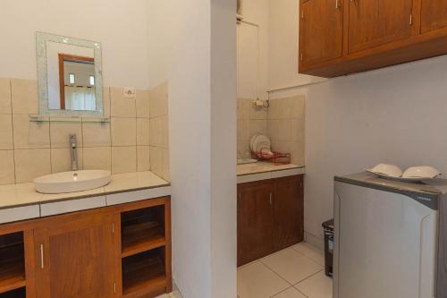 a small kitchen with a sink and a mirror at Uma Sari Ubud Villas in Ubud