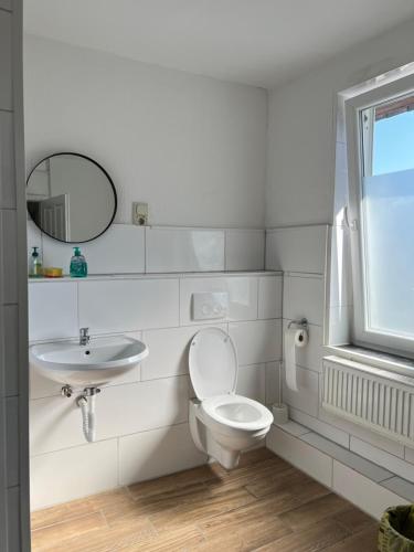 ein weißes Bad mit einem WC und einem Waschbecken in der Unterkunft Zimmervermittlung Hemelingen in Bremen