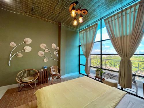 a bedroom with a large bed and large windows at Sea Urchin Homestay in Phan Rang–Tháp Chàm