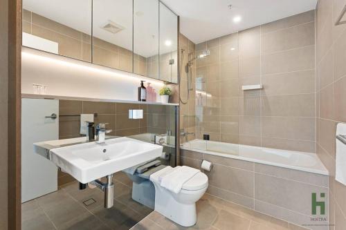 a bathroom with a white sink and a toilet at St Leonards 2B2B Apt with Skyview in Sydney