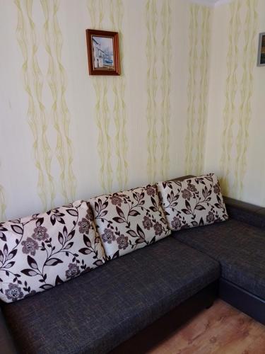 een bank in een woonkamer met zwart-witte gordijnen bij Namas in Klaipėda