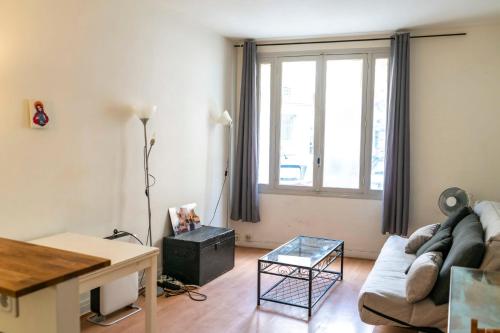 een woonkamer met een bank en een tafel bij Charming Studio With View Near The Sacré Coeur! in Parijs