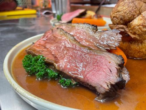 a plate with a piece of meat and gravy at The Golden Cross in Cirencester