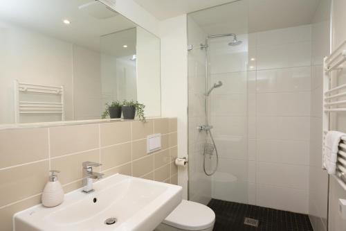 a bathroom with a sink and a toilet and a shower at Holiday at Alexanderplatz Apartments in Berlin