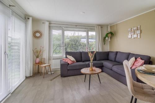 a living room with a blue couch and a table at Chalet aan zee in Retranchement