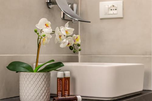 a bathroom with a white tub and a vase with flowers at GIGI HOUSE [appartamento PIAZZA MAZZINI] 300m dal mare in Lido di Jesolo