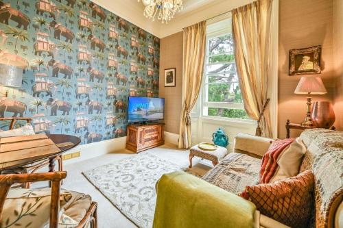 sala de estar con sofá y TV en Gemütliche Wohnung mit einem Schlafzimmer, mit Blick auf den Garten des Anwesens en Torquay