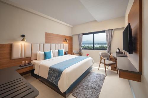 a hotel room with a large bed and a television at Fortune Statue of Unity, Ekta Nagar - Member ITC's Hotel Group in Kevadia