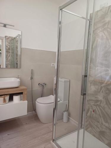 a bathroom with a toilet and a glass shower at Dentro le Mura-Suite House in Sassari