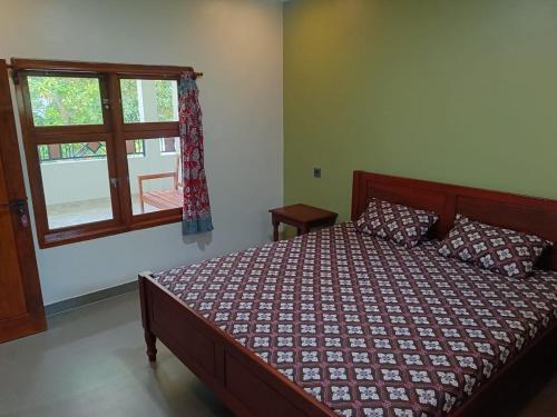 - une chambre avec un lit et une fenêtre dans l'établissement Mango Guesthouse, à Pangandaran