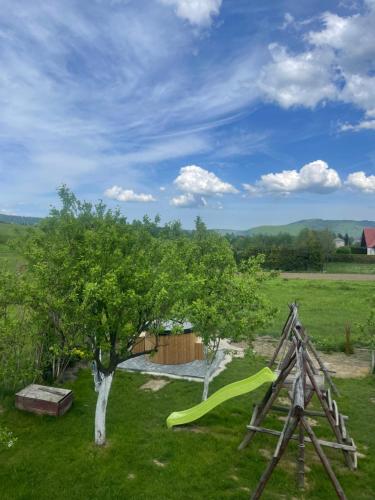 a playground with a slide and a tree at Dudkowe Domki w Beskidach- Relaks z Balią i Apiterapią in Jeleśnia