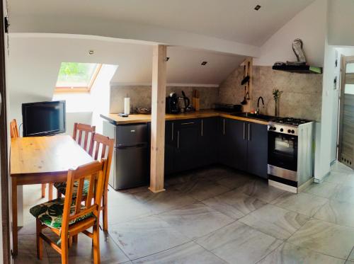 a kitchen with black cabinets and a table and a stove at Apartament Hokus Pokus in Bardo