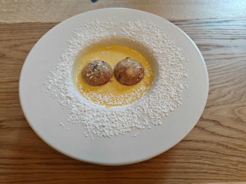 a white plate with two chocolate balls on a table at Schlossberg in San Leonardo in Passiria