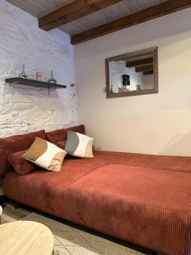 - un canapé rouge dans une pièce avec un miroir dans l'établissement Maison de charme - Cœur de Brest, à Brest