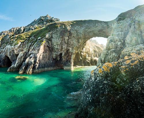 an archway in a rocky cliff over a body of water at Maison de charme - Cœur de Brest in Brest