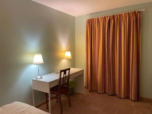 - une chambre avec un bureau, un lit et un bureau avec une lampe dans l'établissement 2 PIECES TERRASSE ET PISCINE PRIVATIVES DANS MAISON TRADITIONNELLE, à Châteauneuf-le-Rouge