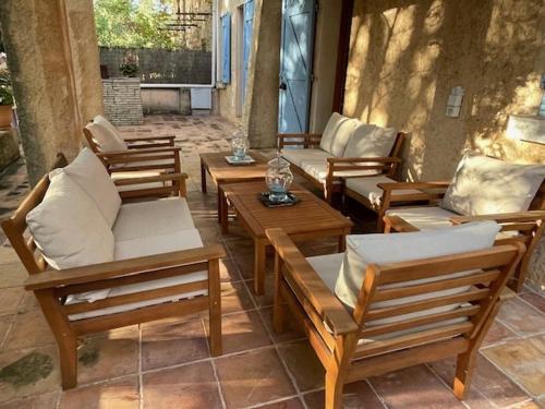 - un ensemble de chaises et de tables en bois sur une terrasse dans l'établissement 2 PIECES TERRASSE ET PISCINE PRIVATIVES DANS MAISON TRADITIONNELLE, à Châteauneuf-le-Rouge