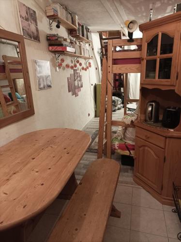 einen Tisch und Bänke in einem Zimmer mit Etagenbett in der Unterkunft Atypique Briançon Cosy in Briançon