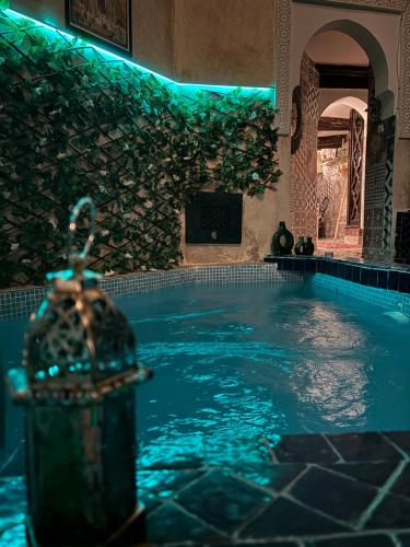 a swimming pool with a water fountain in a building at Riad Sanwa in Marrakesh